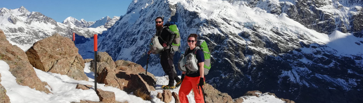 two people standing on a snowy mountain wearing Aarn Backpacks