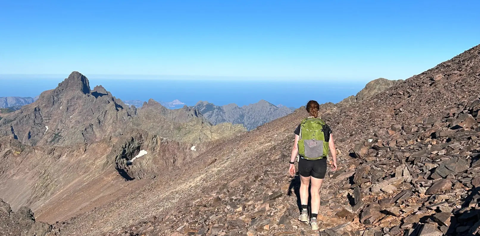 A woman is fastpacking along the GR20 in Corsica, with her Aarn Pace Magic 30L hiking backpack.